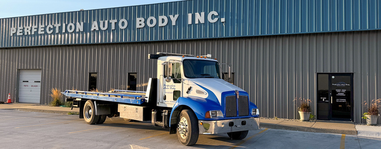 24/7 towing service truck by Perfection Auto Body building